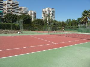 a tennis court with buildings in the background at Apartment Playamar by Interhome in Torremolinos