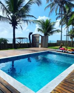 a swimming pool with a view of the ocean at Villa do Sossego - Caraíva in Caraíva