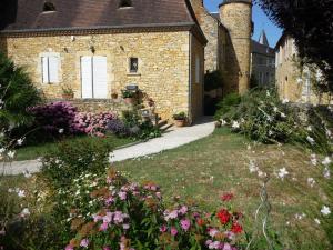 a brick house with a garden with flowers in the yard at Gîte dans propriété périgourdine in Pechpialat