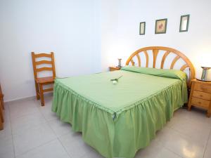 Un dormitorio con una cama con una manta verde encima. en Apartment Topacio IV-1 by Interhome, en Calpe
