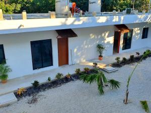 a white house with plants in front of it at Villas Chital Bacalar in Bacalar