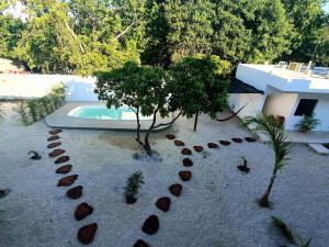 a backyard with a swimming pool and trees and rocks at Villas Chital Bacalar in Bacalar