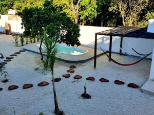 a small tree in the sand next to a swimming pool at Villas Chital Bacalar in Bacalar +13 photos