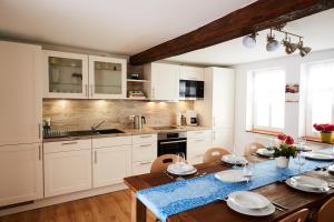 a kitchen with white cabinets and a wooden table at Ferienhaus Behringen in Behringen