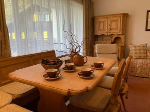 uma mesa de madeira com copos na sala de estar em Cosy apartment in a gorgeous area em Crans-Montana