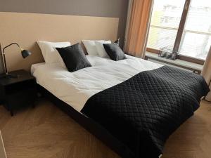 duże łóżko z czarno-białą pościelą i poduszkami w obiekcie Apartament Ogrodowa Deluxe w Warszawie