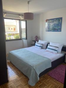 a bedroom with a large bed with white sheets and pillows at Apartment Melina in Omišalj