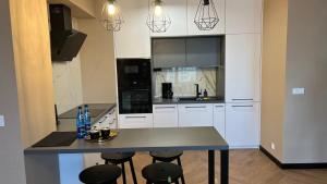 a kitchen with a table and stools in it at Apartament Ogrodowa Deluxe in Warsaw