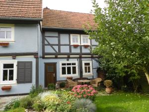 una casa bianca con un cortile fiorito di Ferienhaus Behringen a Behringen