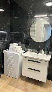 a bathroom with a white sink and a mirror at Apartament Ogrodowa Deluxe in Warsaw