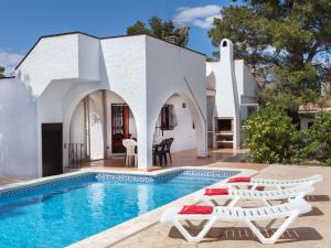 a villa with a swimming pool and two lounge chairs at Villa Villa Zozo by Interhome in L'Ametlla de Mar