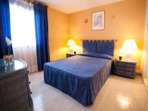 a bedroom with a blue bed and a window at Apartment Turquesa Beach 03 by Interhome in Calpe
