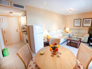 una cucina e un soggiorno con tavolo e sedie di Apartment Turquesa Beach 03 by Interhome a Calpe