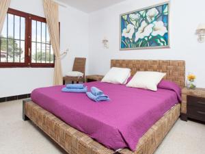 ミアミ・プラトーヤにあるVilla Arcada by Interhomeのベッドルーム1室(紫のシーツが敷かれた大型ベッド1台付)