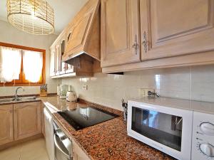 een keuken met een wastafel en een magnetron bij Holiday Home Esperanza by Interhome in Benitachell