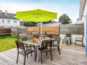 einen Tisch und Stühle mit einem gelben Regenschirm auf einer Terrasse in der Unterkunft Holiday Home Penthievre by Interhome in Légenès