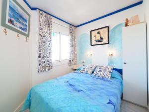 エンプリアブラバにあるApartment Club Nautic-17 by Interhomeのベッドルーム(青いベッド1台、窓付)