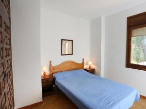 a bedroom with a blue bed and two night stands at Villa Villa Illot by Interhome in Les tres Cales