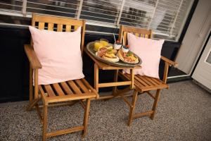 two chairs with a plate of food on a table at B&Bslapenopeeneiland in Kaag