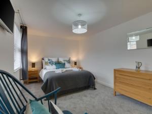 a bedroom with a bed and a dresser at Holiday Home Glynn Terrace by Interhome in Padstow