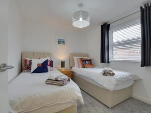 um quarto com 2 camas e uma janela em Holiday Home Glynn Terrace by Interhome em Padstow