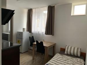 a small room with a table and chairs and a bed at Beregi Apartman in Tiszaújváros