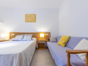 カンブリルスにあるApartment Carme by Interhomeのベッド2台とソファが備わるホテルルームです。
