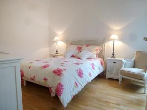 a bedroom with a bed with pink flowers on it at Holiday Home Villa Morny by Interhome in Deauville