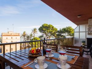 a table with wine glasses and a basket of fruit on a balcony at Apartment Sorts de la Mar-1 by Interhome in Denia