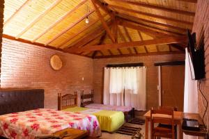 リマ・ドゥアルテにあるAconchegante chalé em Conceição do Ibitipoca - MGのベッドが2つあり、天井が木製の寝室