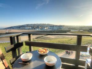 a table with two bowls of food on a balcony at Apartment Les Marinas-6 by Interhome in Deauville