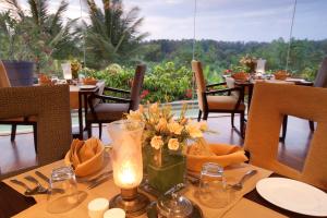 una mesa con un jarrón de flores en la parte superior en The Serai Chickmagalur en Chikmagalūr