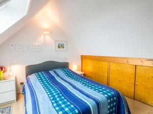 Un dormitorio con una cama con una manta azul y blanca. en Apartment MEN DU-2 by Interhome, en Carnac