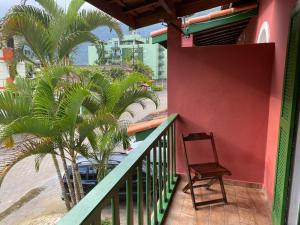 una silla sentada en un balcón junto a la playa en Chalés Sol da Ribeira, en Ubatuba