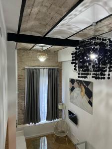 a living room with a window and a chandelier at CASA ENEKO in Seville