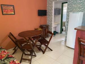 comedor con mesa, sillas y TV en Chalés Sol da Ribeira, en Ubatuba