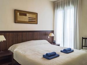 a bedroom with a bed with two blue towels on it at Apartment Alamar by Interhome in La Cala de Mijas