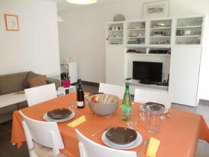 a dining room table with a orange table cloth and a bowl on it at Apartment Nautica by Interhome in Saint Malo