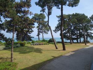 a park with trees and the ocean in the background at Apartment Baie de Beaumer-1 by Interhome in Carnac