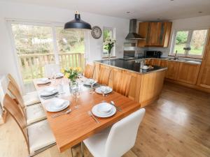 cocina y comedor con mesa de madera y sillas en The Dingle, en Narberth