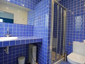 ムンロッチ・ダル・カムにあるHoliday Home Marabou 2-0 by Interhomeの青いタイル張りのバスルーム(トイレ、シンク付)