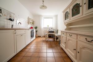 a kitchen with white cabinets and a tile floor at 2 BR City Apartment in Neubau, 6 min to city center in Vienna