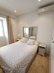 1 dormitorio con cama y espejo en Azvalia - Ático Larga 112 - Terraza, en El Puerto de Santa María