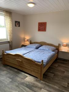 a bedroom with a large wooden bed with blue sheets at Harms, Ferienwohnung in Südbrookmerland