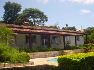 una casa con piscina delante en Chácara do Sossego, en Piracaia