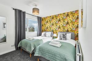 2 camas en un dormitorio con papel pintado floral en Charming 2 bed home, quiet village + free parking en Halifax
