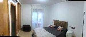 ein Schlafzimmer mit einem Bett mit einer schwarzen Decke und Kissen in der Unterkunft Motorhome beach house in San José