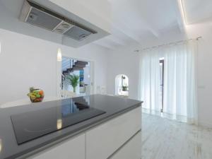 cocina con armarios blancos y encimera negra en Holiday Home Es Reco by Interhome, en Costitx