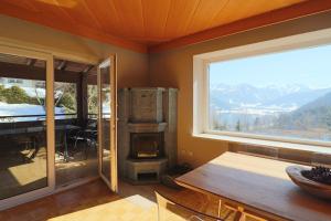 a living room with a fireplace and a table and a window at Chalet Lake View - Pinzgau Holidays in Zell am See