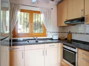 a kitchen with white cabinets and a sink and a window at Holiday Home Hope by Interhome in Adsubia